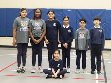 Group of 7 student leaders in the gym, pose for photo